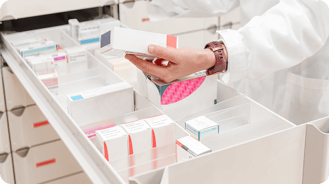 Pharmacist organizing medication on a shelf